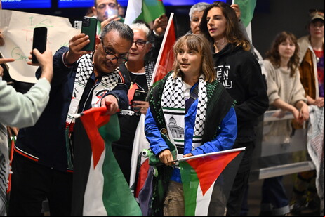 Greta Thunberg em meio a bandeiras da Palestina no aeroporto de Estocolmo